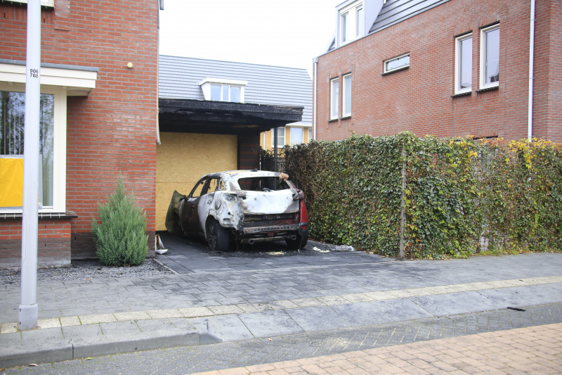 Auto in lichterlaaie onder carport van woning