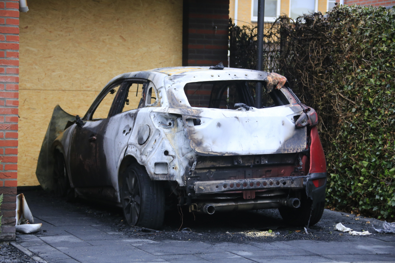 Auto in lichterlaaie onder carport van woning