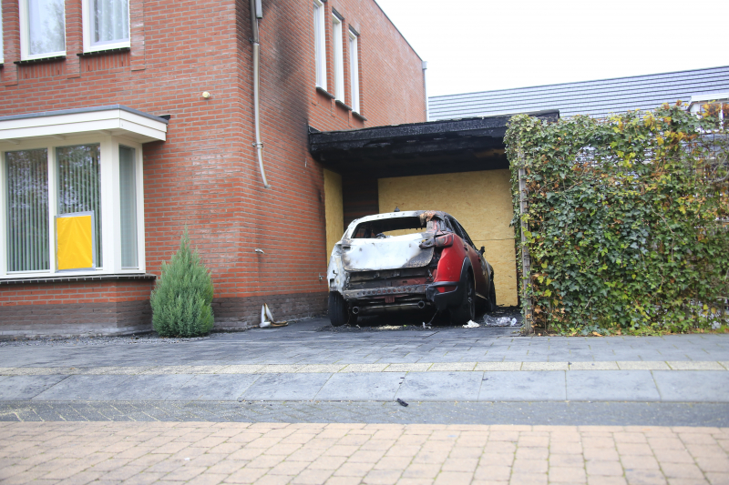 Auto in lichterlaaie onder carport van woning