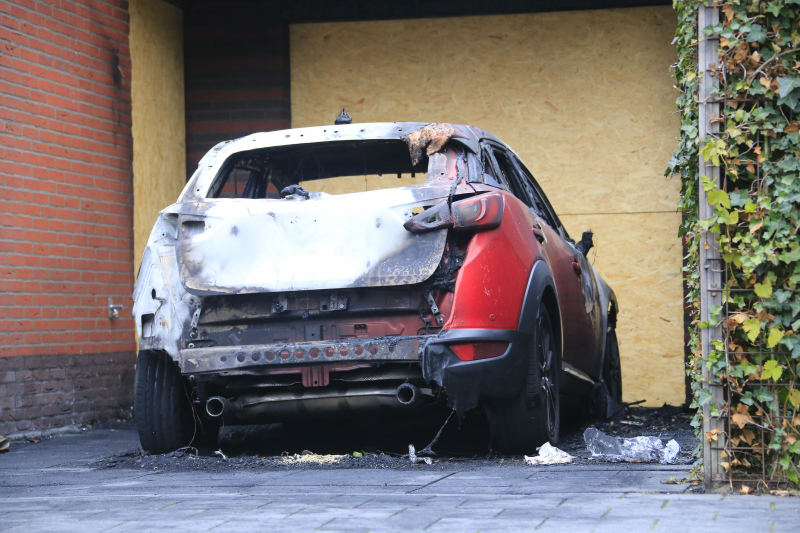 Auto in lichterlaaie onder carport van woning