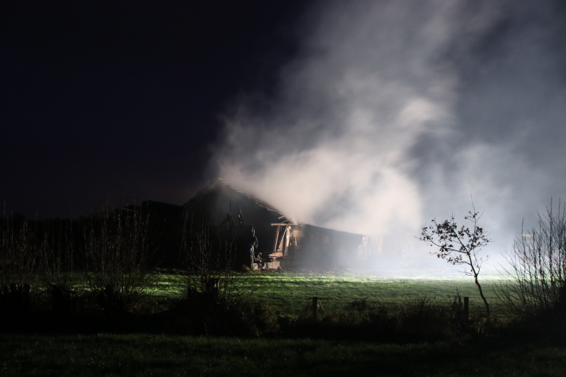 Schuur met rietenkap in brand