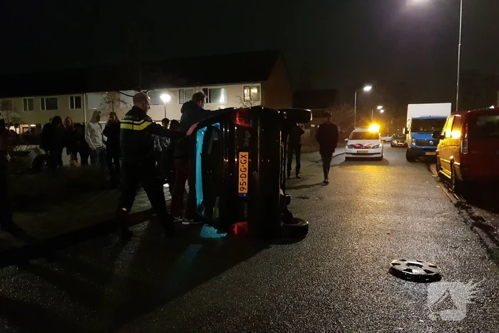 Bestuurster bekneld na auto op zijn kant