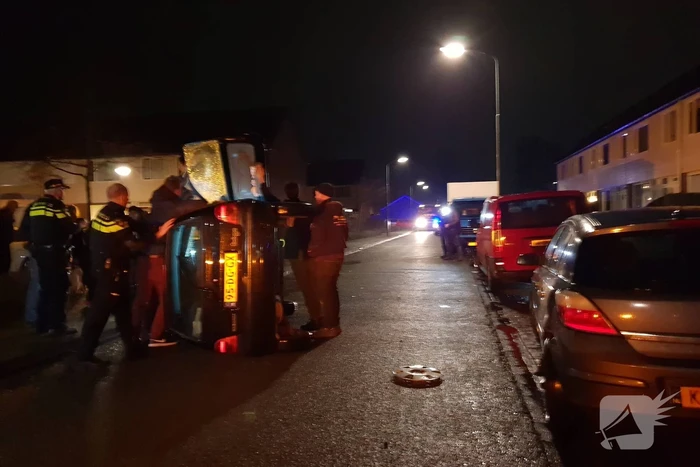 Bestuurster bekneld na auto op zijn kant