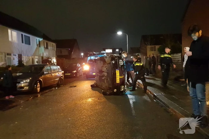 Bestuurster bekneld na auto op zijn kant