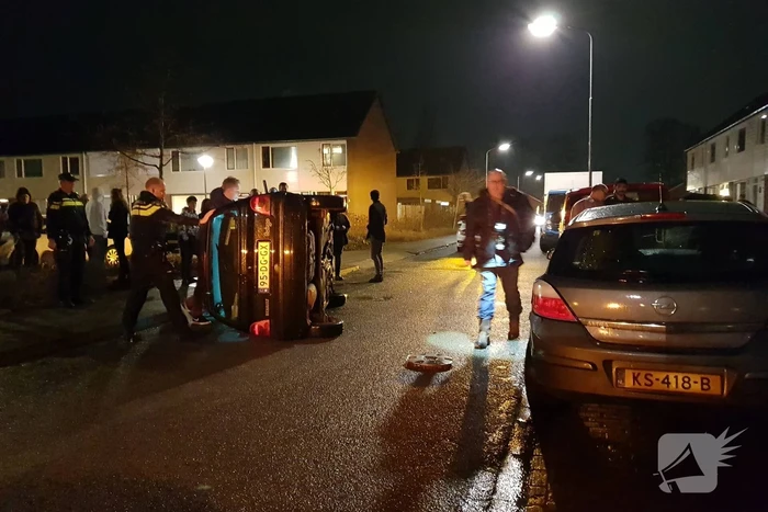 Bestuurster bekneld na auto op zijn kant