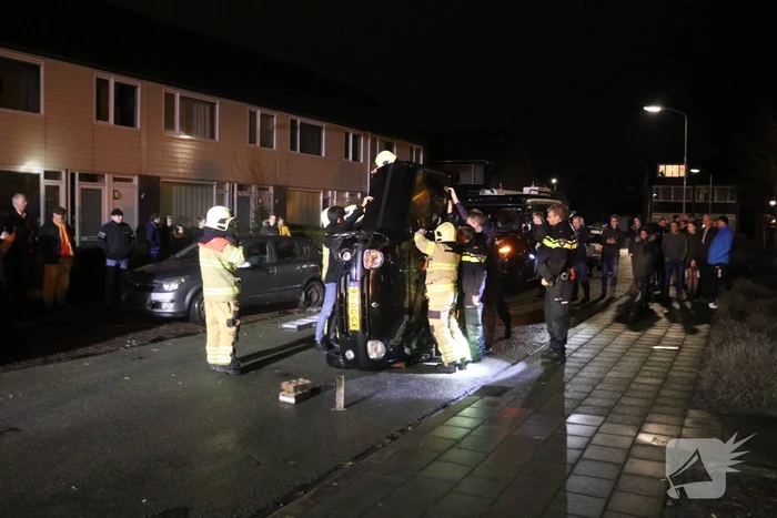 Bestuurster bekneld na auto op zijn kant