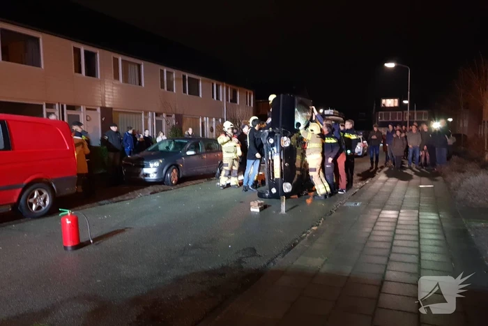Bestuurster bekneld na auto op zijn kant