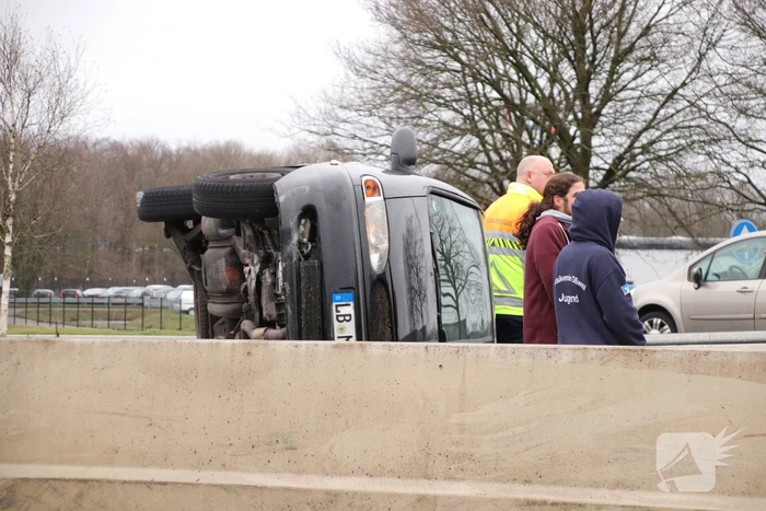 Auto vliegt over middengelijder en belandt op zijkant