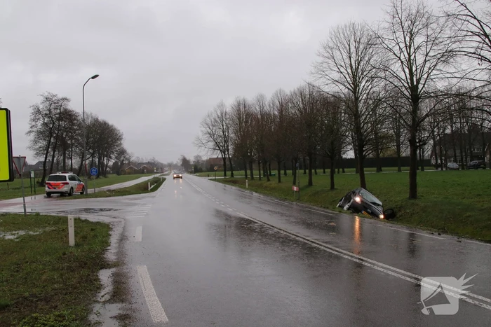 Auto schiet over kruising de sloot in