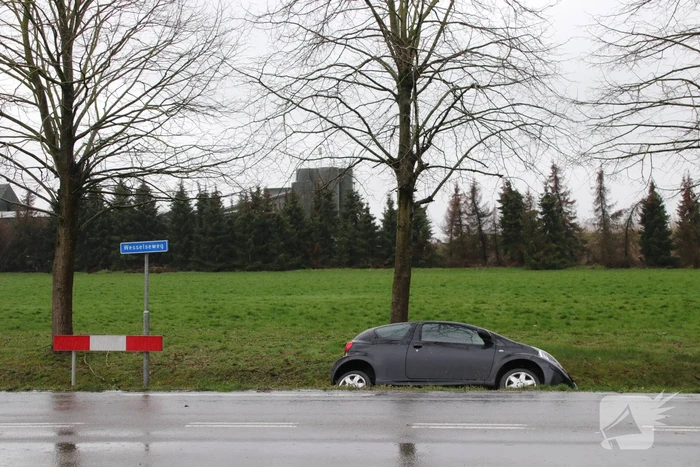Auto schiet over kruising de sloot in