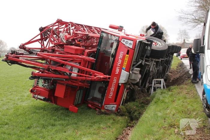 Kraanwagen belandt in weiland