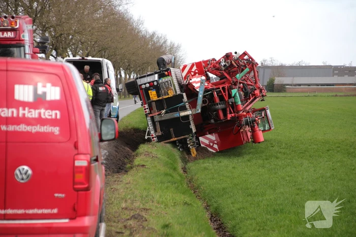 Kraanwagen belandt in weiland