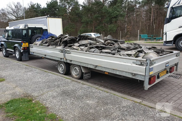 Auto met zware aanhanger dakpannen belandt in vangrail