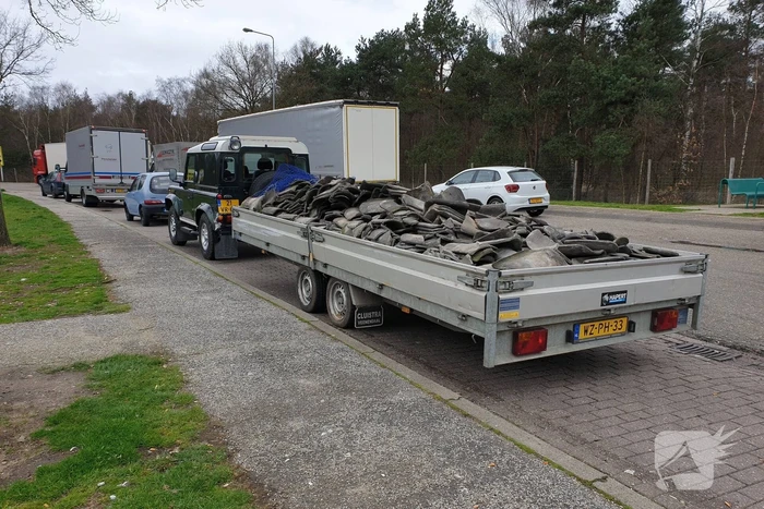 Auto met zware aanhanger dakpannen belandt in vangrail