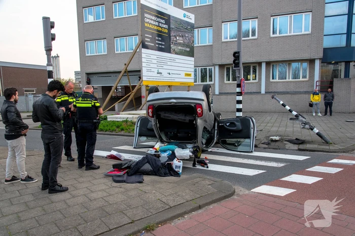 Automobilist over de kop na rammen stoplicht