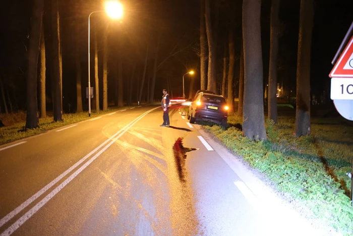 Motor van auto geklapt, oliespoor op de weg