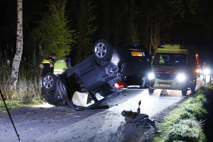 Auto beland op zijn dak na botsing met boom