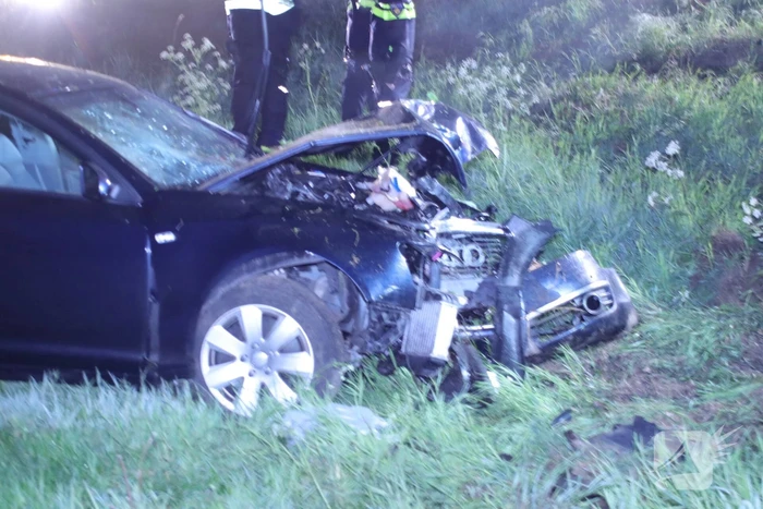 Auto belandt naast de snelweg