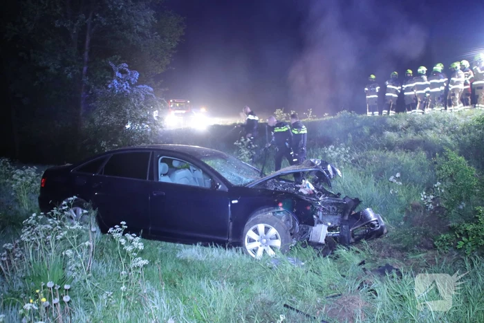 Auto belandt naast de snelweg