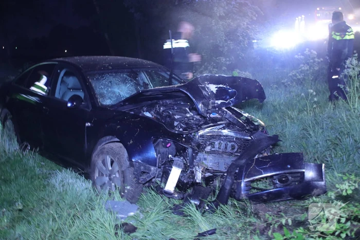 Auto belandt naast de snelweg