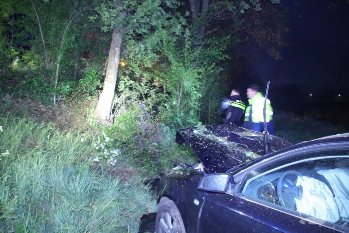 Auto belandt naast de snelweg