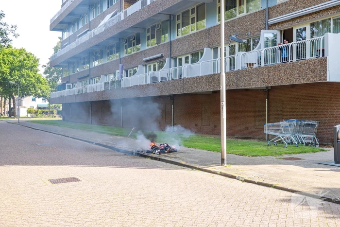Omstanders blussen brand in kledingzak