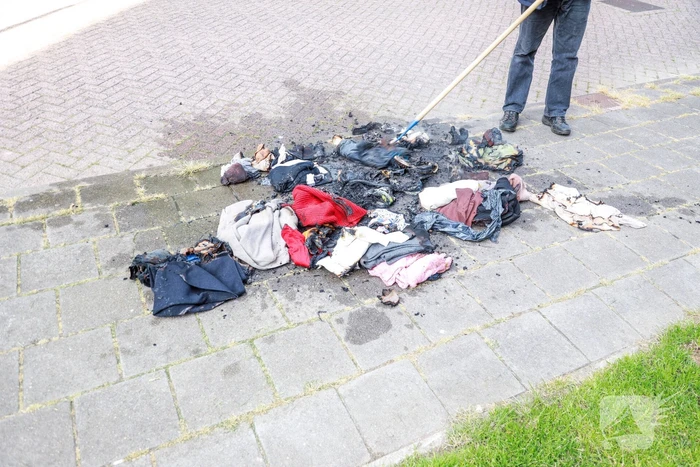 Omstanders blussen brand in kledingzak