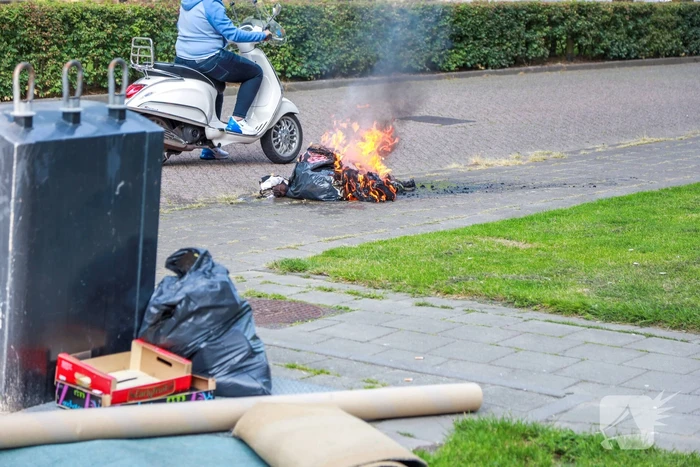 Omstanders blussen brand in kledingzak