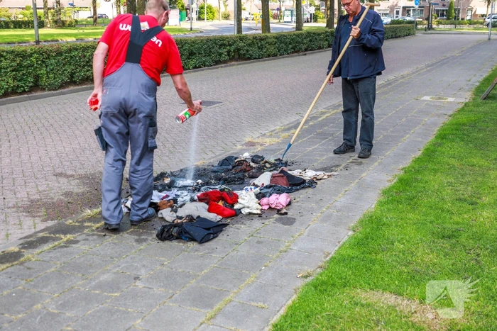 Omstanders blussen brand in kledingzak