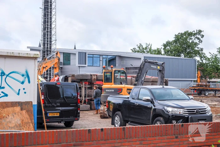 Vrachtwagen kantelt op bouwterrein