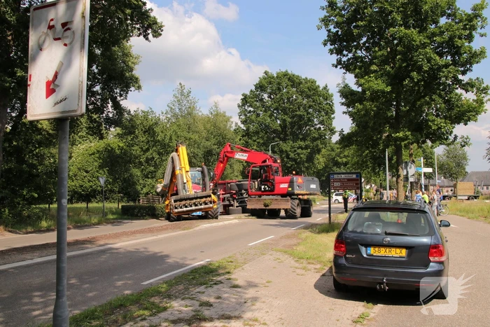 Kar met maai-afval achter trekker kantelt