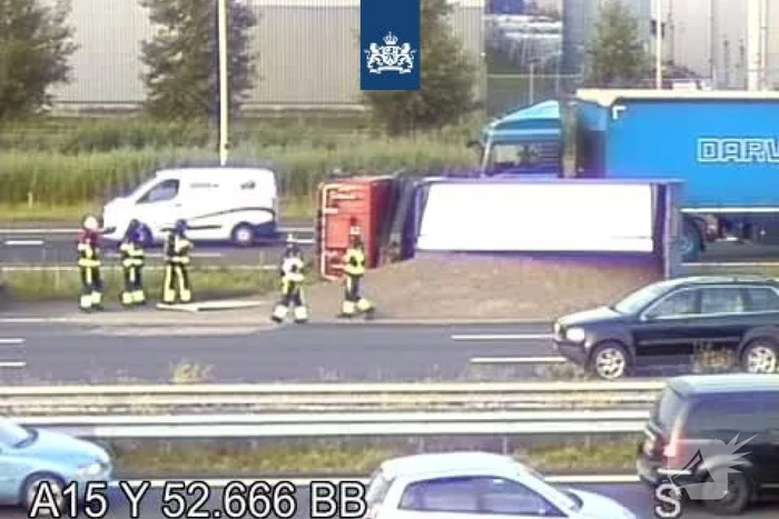 Vrachtwagen met zand kantelt op snelweg