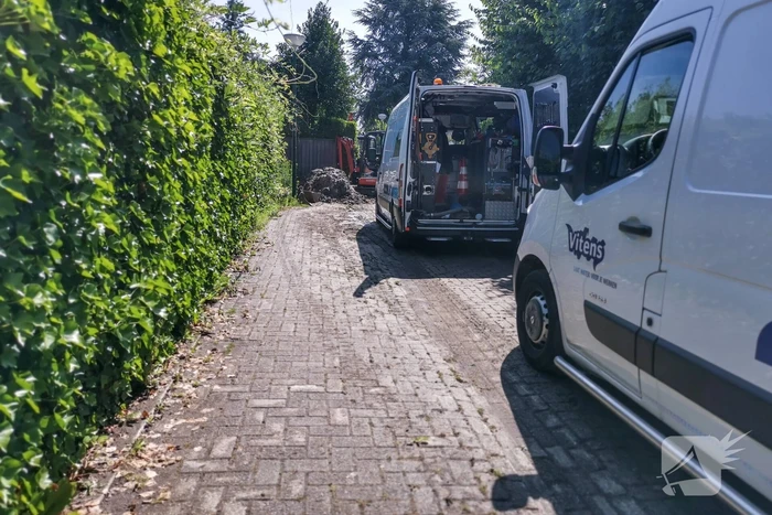 Smalle weg afgesloten door gesprongen waterleiding