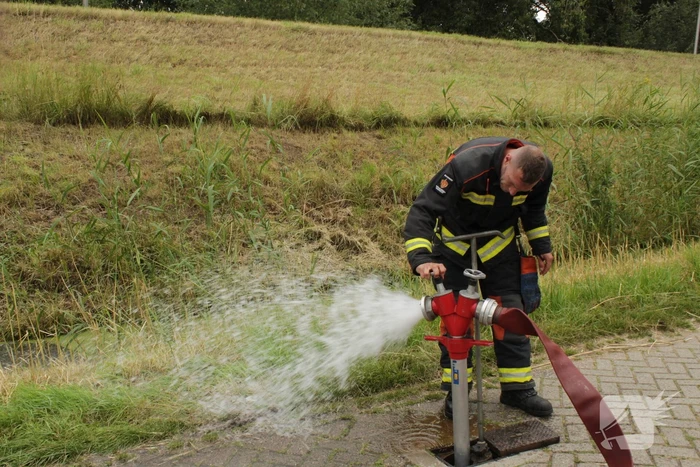 Brandweer blust smeulende hooibalen