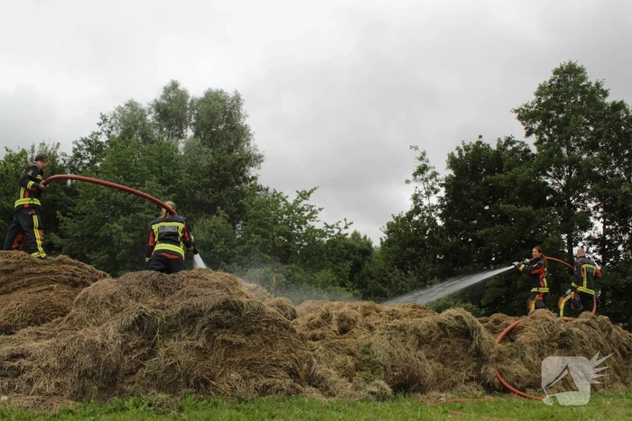 Brandweer blust smeulende hooibalen