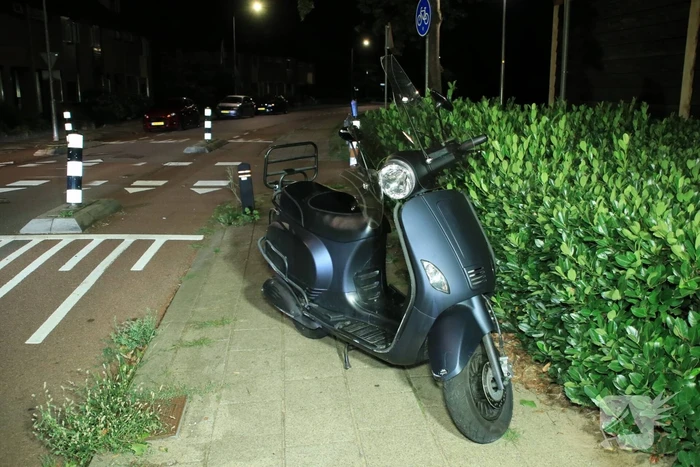 Snorscooter klapt op paal bij oversteekplaats, jonge dame buiten westen
