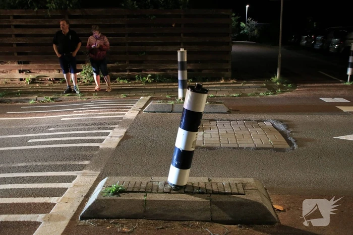 Snorscooter klapt op paal bij oversteekplaats, jonge dame buiten westen