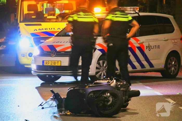 Snorscooter klapt op paal bij oversteekplaats, jonge dame buiten westen