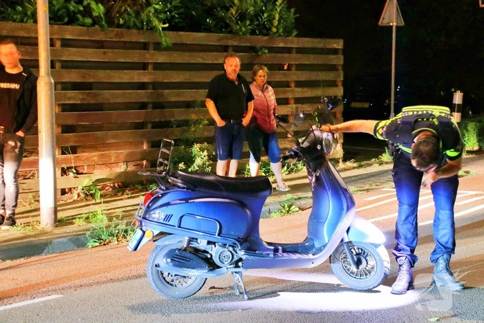 Snorscooter klapt op paal bij oversteekplaats, jonge dame buiten westen