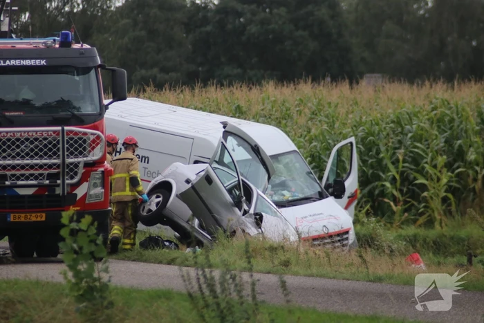 Bestelbus en auto belandt in greppel na botsing
