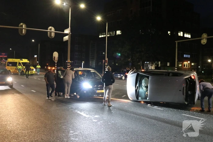 Auto belandt op zijkant na botsing; inzittende gewond bij reddingsactie