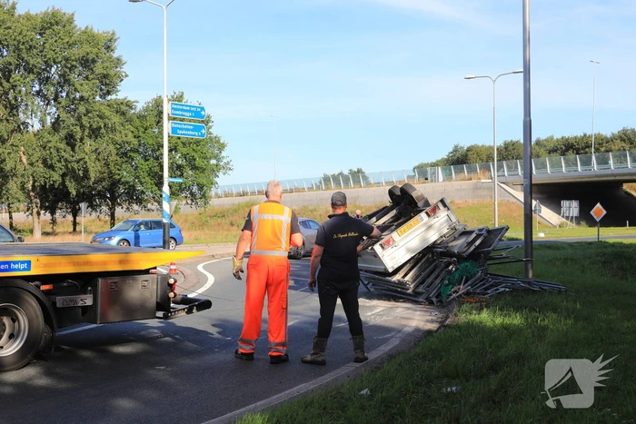 Aanhangwagen met steigerdelen kantelt