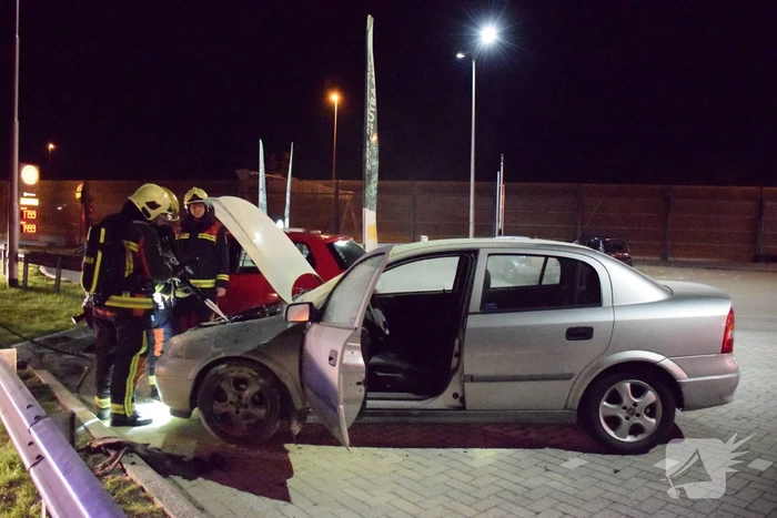 Omstanders blussen brandende auto