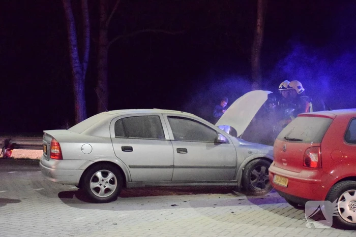 Omstanders blussen brandende auto