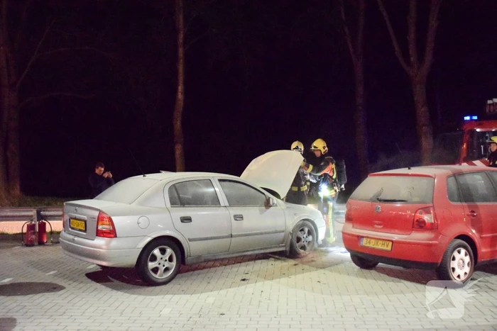 Omstanders blussen brandende auto