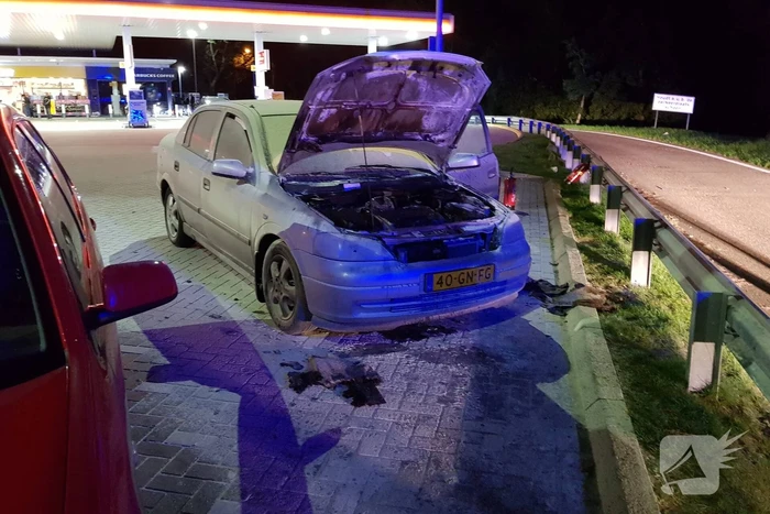 Omstanders blussen brandende auto
