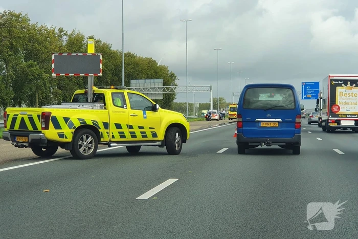 Auto over de kop naast snelweg