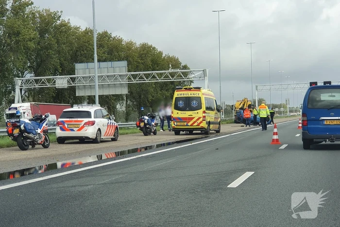 Auto over de kop naast snelweg