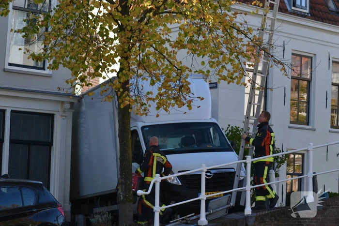 Bezorger rijdt vrachtwagen vast tegen dakgoot