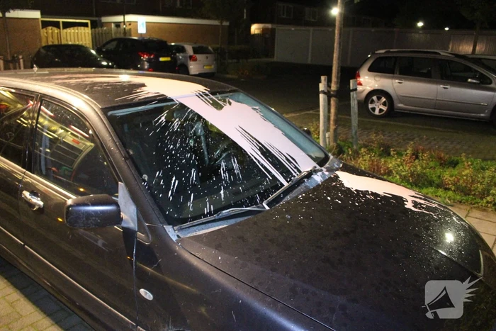 Auto met vloeistof besmeurd, schutting in brand gestoken